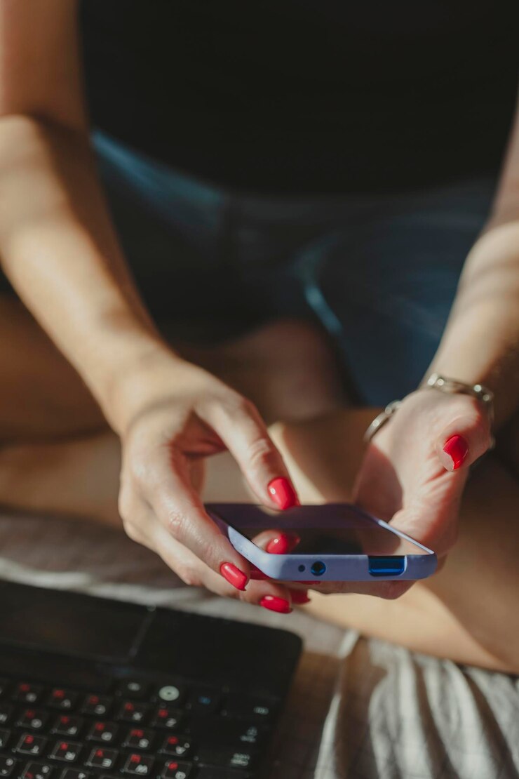 Foto mulher enviando mensagens de texto usando mãos de telefone móvel com manicure de esmalte de unhas vermelho em enquadramento de compras on-line