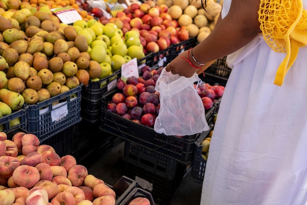 Mulher escolhe frutas e legumes no mercado de agricultores