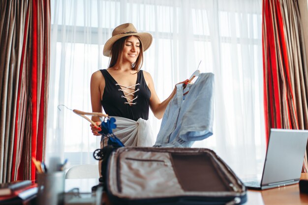 Mulher escolhe roupas, pensando na viagem