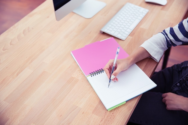 Mulher escrevendo notas no escritório