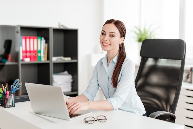 Mulher, escritório, escrivaninha, laptop, sorrindo