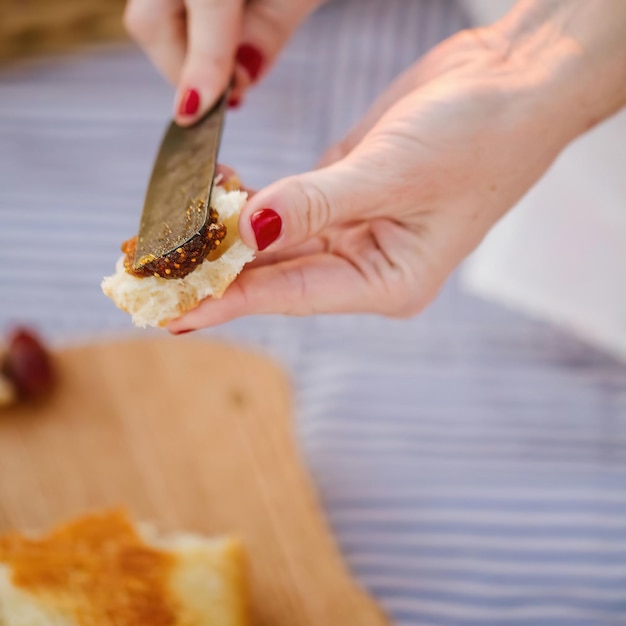 Mulher espalhando geléia em um pão de perto