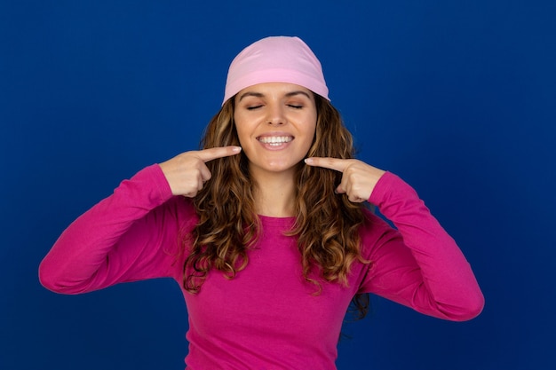 Foto mulher esperançosa usando um lenço rosa isolado em uma parede branca