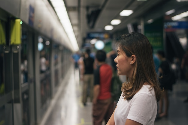 Foto mulher, esperando, ligado, a, plataforma estação, e, usando, esperto, telefone, em, a, aeroporto, link, estação