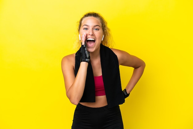 Mulher esporte com toalha isolada em fundo amarelo gritando com a boca bem aberta