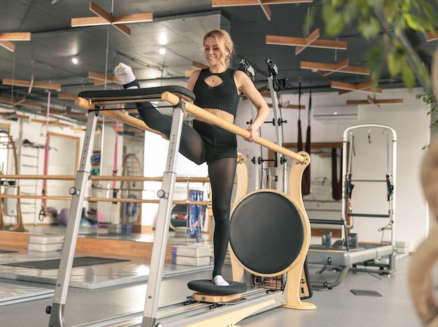 Mulher esportiva fazendo exercícios de alongamento em um estúdio moderno