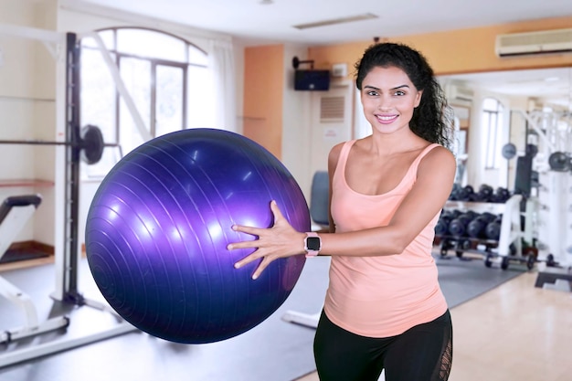 Mulher esportiva feliz segurando uma bola de ioga