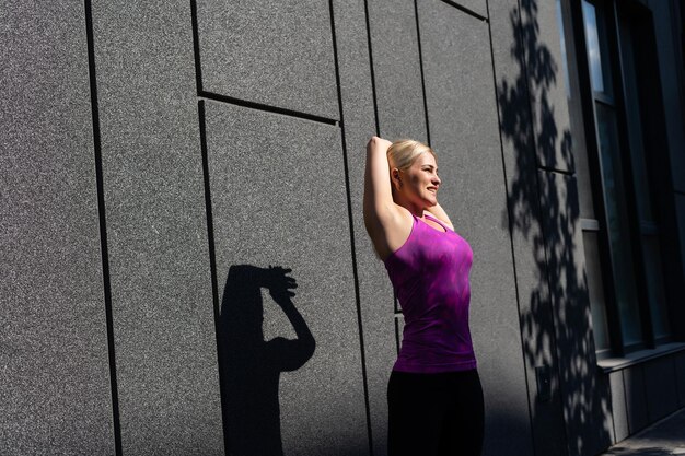 Mulher esportiva fitness em roupas esportivas de moda fazendo exercícios de ioga na rua, esportes ao ar livre, estilo urbano