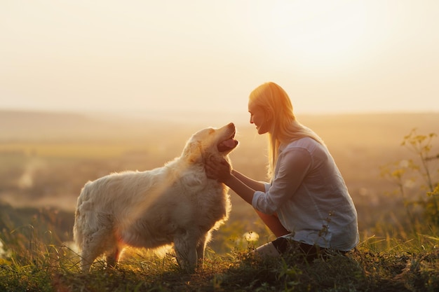 mulher está abraçando seu cachorro de raça grande