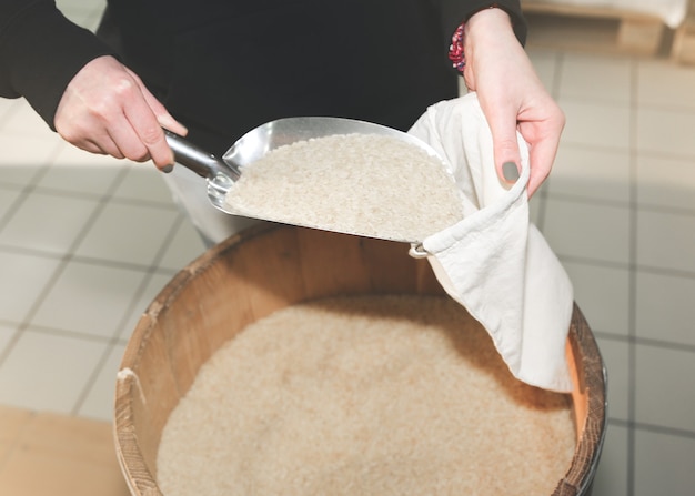 Mulher está colocando arroz em uma sacola de compras reutilizável. Pacotes ecologicamente e ecologicamente corretos. Tecidos de lona e linho. Salve o conceito de natureza. Nenhum plástico de uso único em supermercados.
