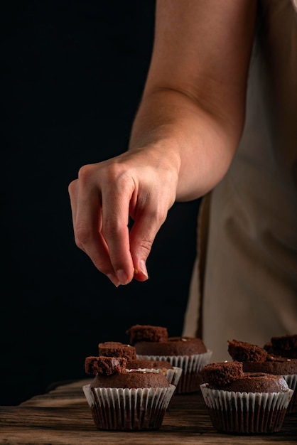 Mulher está cozinhando pastelaria O chef de pastelaria enche os cupcakes com o recheio Processo de fazer muffins de chocolate Espaço para cópia Moldura vertical