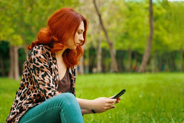 Mulher está digitando uma mensagem no seu celular