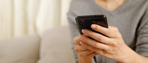 Mulher está jogando jogos no smartphone