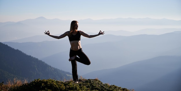 Foto mulher está praticando ioga nas montanhas