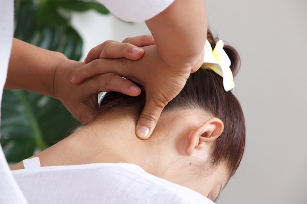 Mulher está tendo massagem no pescoço em estilo tailandês