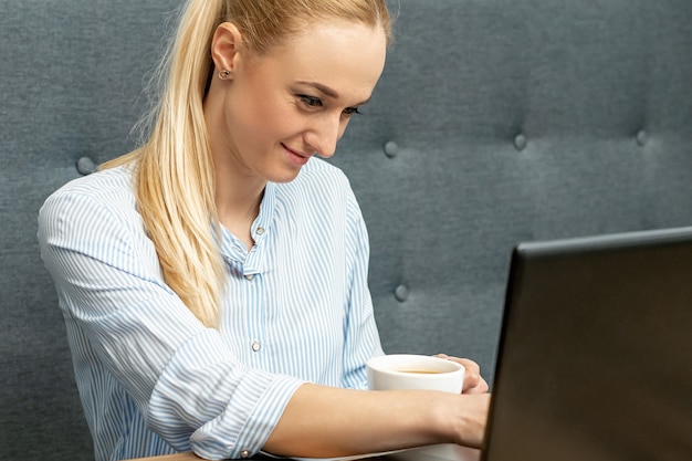 Mulher está trabalhando no laptop no escritório em casa.