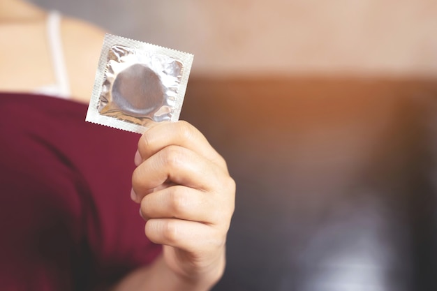 Mulher está usando camisinha para prevenir a AIDS.