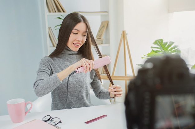 mulher está usando um dispositivo especial para esticar o cabelo