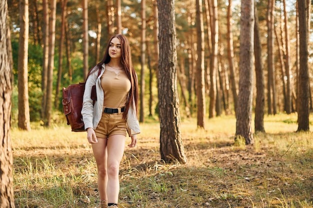 Mulher está viajando sozinha na floresta durante o dia no verão