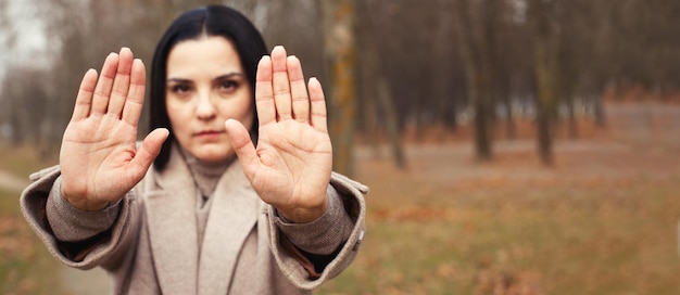 Mulher esticando as mãos com as palmas abertas como um sinal de pare