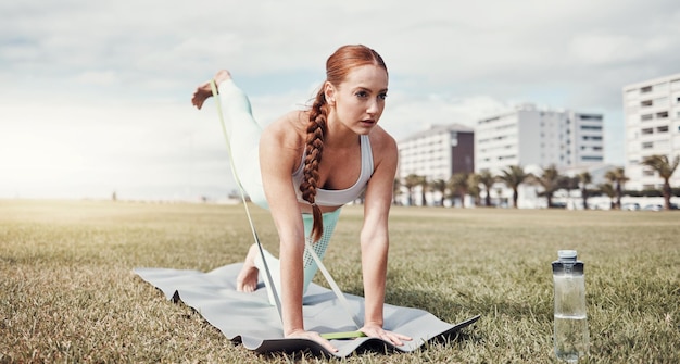 Mulher esticando as pernas e banda de resistência na cidade para exercício de treino ou treinamento no tapete de ioga Ioga feminina em estiramento de perna de aquecimento e cinta elástica para bem-estar saudável ou fitness na Cidade do Cabo