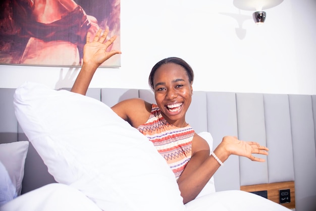 Mulher esticando na cama e sorrindo