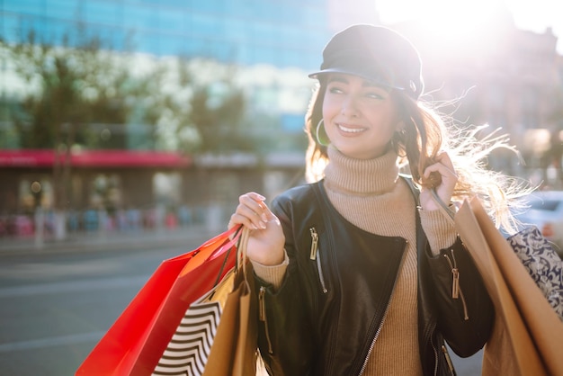 Foto mulher estilosa com sacolas de compras caminha pelas ruas da cidade spring style