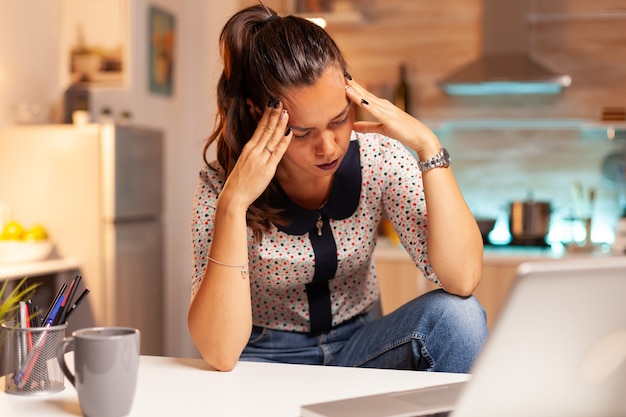 Mulher estressada fazendo hora extra sente fadiga ocular depois do trabalho no computador tarde da noite. funcionário que usa tecnologia moderna à meia-noite fazendo horas extras para trabalho, negócios, ocupado, carreira, rede, estilo de vida.