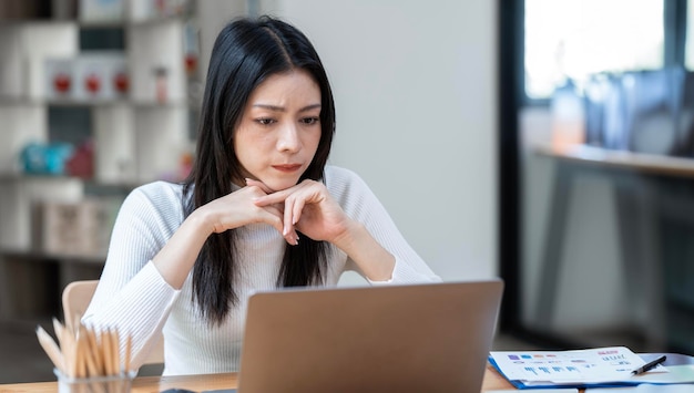 Mulher estressada trabalhando no laptop em casa