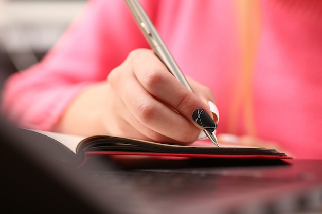 Mulher estudando muito, anotando informações no caderno