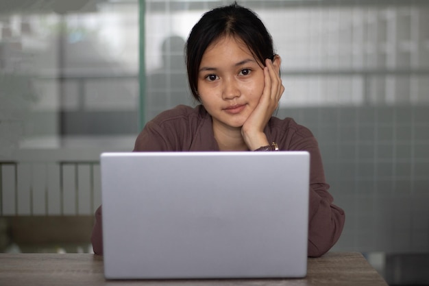 Mulher estudante asiática trabalhando em um laptop durante o dia