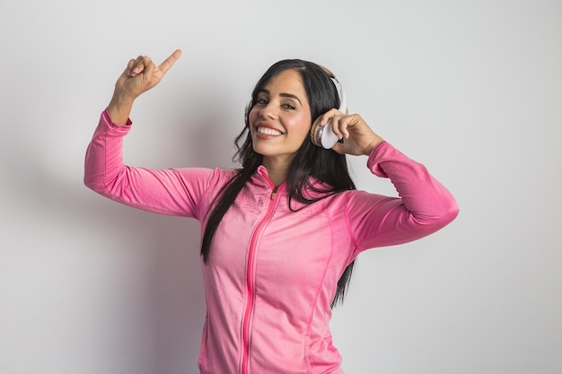 Mulher étnica sorridente na jaqueta esportiva, ouvindo música