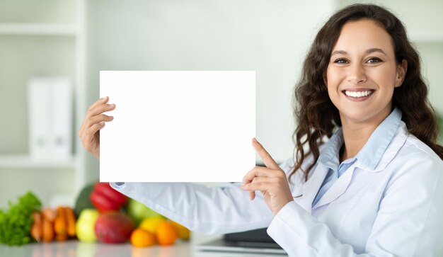 Mulher europeia alegre médico nutricionista mostrando quadro branco em branco