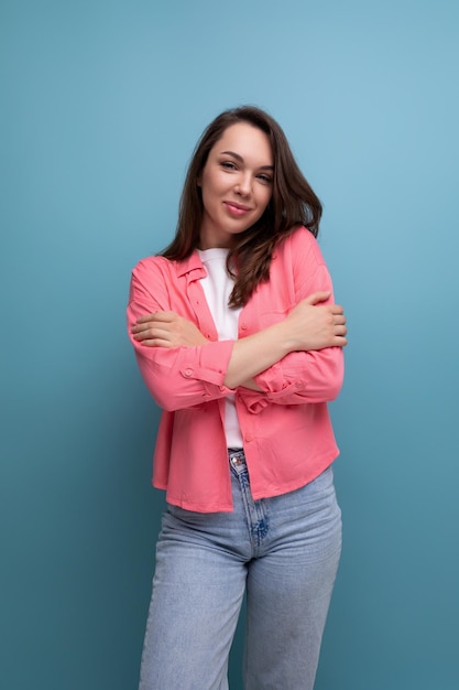 Mulher europeia bonita e bonita com camisa rosa, fundo de estúdio isolado.