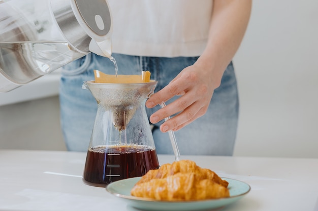 Mulher europeia fazendo café em casa na cozinha e aproveitando seu bom dia