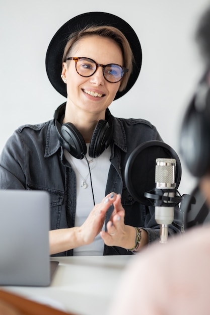 Mulher européia jovem e confiante gravando um podcast em um estúdio de gravação