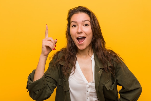 Mulher européia nova isolada sobre o amarelo que tem uma ideia, inspiração.