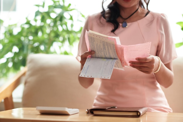 Mulher examinando recibos em casa