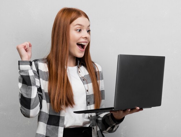 Foto mulher excitada segurando laptop tiro do estúdio