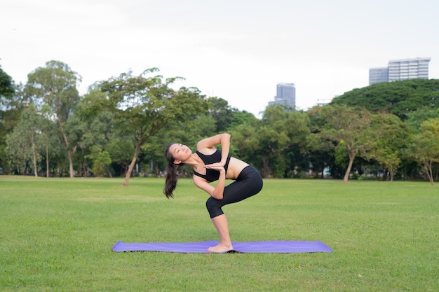 Mulher exercita ioga no parque, pronta para um estilo de vida saudável na natureza