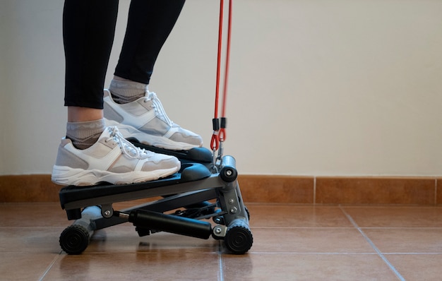 Mulher exercitando em casa com uma etapa hidráulica