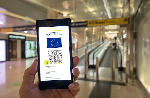 Mulher exibindo certificado digital covid da ue em smartphone