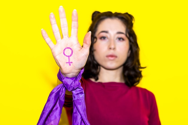 Mulher exibindo símbolo feminino na mão pela igualdade