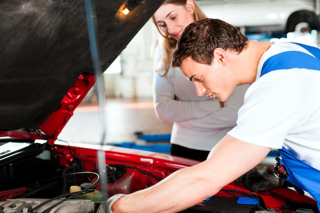 Foto mulher falando com mecânico de automóveis na oficina