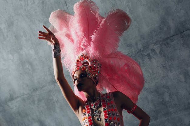 Mulher fantasiada de samba ou lambada com plumagem de plumas rosa.