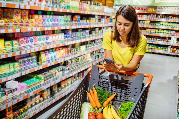 Mulher faz compras para comprar lista no telefone