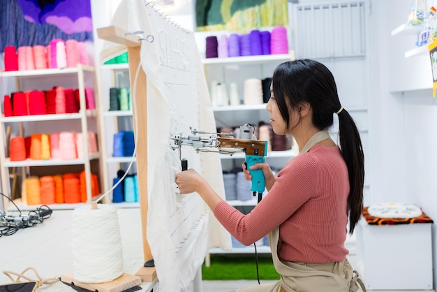 Mulher faz de tapete tufting no estúdio