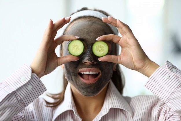 Mulher faz máscara facial de argila cinza em casa