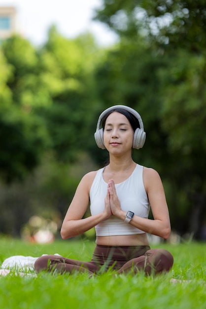 Mulher faz meditação no parque