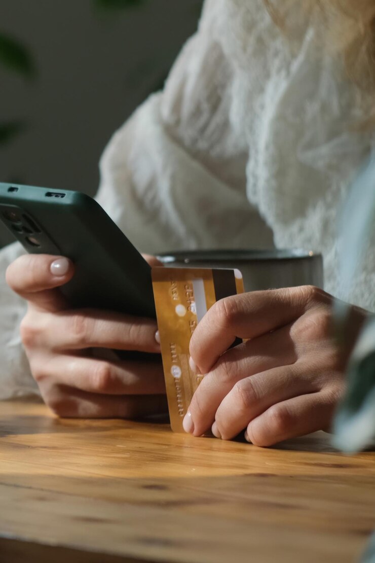 Mulher faz pagamentos on-line usando cartão bancário de plástico e smartphone